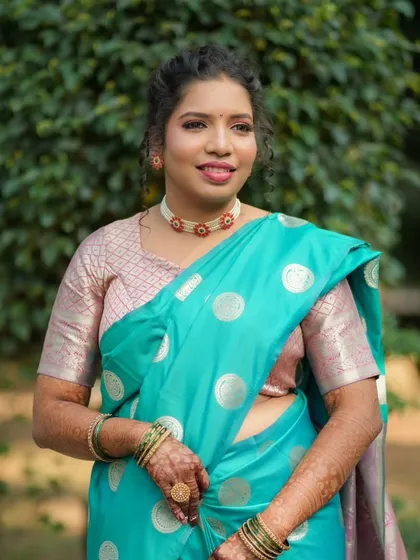 A beautiful portrait of a client for her engagement pooja. She wears a lovely turquoise saree with subtle makeup that enhances her features.