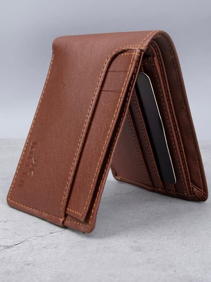 A brown leather wallet standing upright to display its slim profile and card slots.