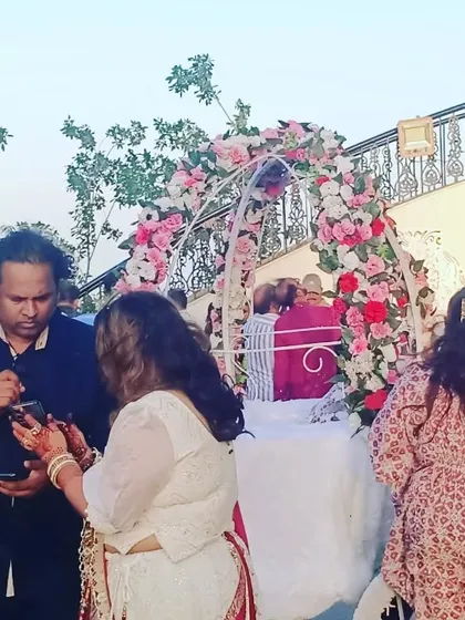 A floral arch set up for a cake-cutting ceremony or as a photo point at an outdoor event. This provides a beautiful frame for key moments of the celebration.