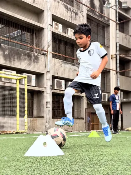 Mastering the ball is key. Here, a player practices a step-over on a stationary ball, building the muscle memory needed for advanced dribbling techniques.
