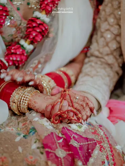 The sacred thread that binds two hands and two hearts. This close-up shot captures the significance of the wedding rituals and the promise of a shared future.