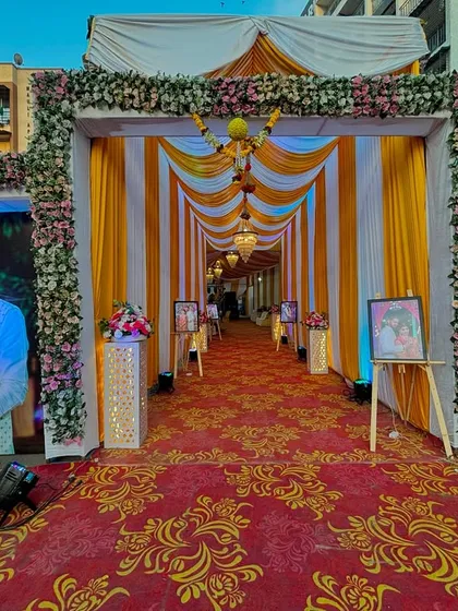 We love adding a personal touch, especially for our Aagri and Koli clients. This entrance features large, welcoming portraits of the couple, a lush floral arch, and a vibrant walkway, making guests feel special from the moment they arrive.