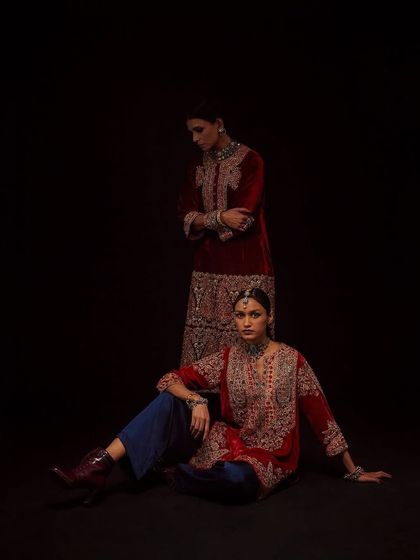 A dramatic shot for Debyani & Co against a black background, using lighting to sculpt the models and highlight the velvet textures.