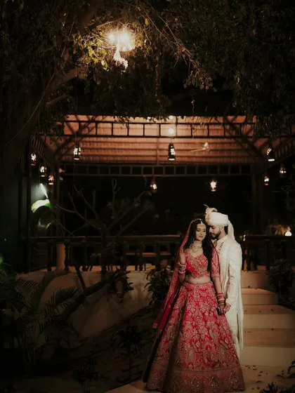 A nighttime portrait under a beautifully lit gazebo. I use the warm, ambient lighting to create a romantic and intimate atmosphere, capturing the couple in their stunning wedding attire after the ceremony.