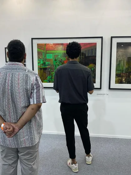 Visitors looking at the vibrant, layered photographs by Sandeep T K.