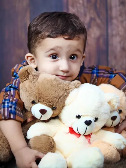 A sweet toddler portrait, hugging his teddy bears. These sessions are perfect for capturing the bond between a child and their favorite toys.