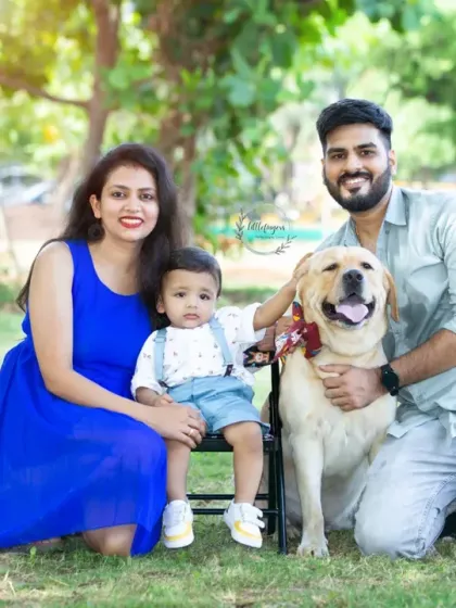 A happy family of three posing with their beloved Labrador. I always encourage bringing furry family members along for the shoot; they are part of your story too.