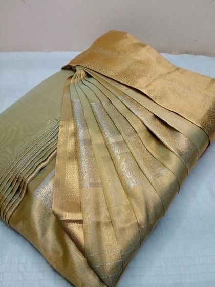 A simple yet elegant gold tissue saree. Even on plain sarees, perfect pleats make a huge difference in the overall appearance.