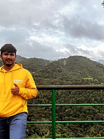 A Tripbae team member in our signature hoodie, enjoying the view of the lush green hills. We live and breathe the adventures we create.