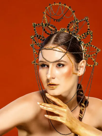 A model wears an elaborate, custom-made headpiece against a vibrant red background. This is an example of our high-concept editorial work, perfect for fashion magazines or avant-garde designers.