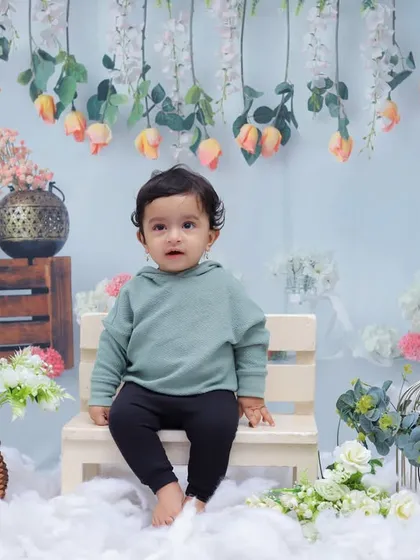 This little one looks calm and curious in our cloud and flower-themed studio set. We create serene environments to capture beautiful, peaceful portraits.