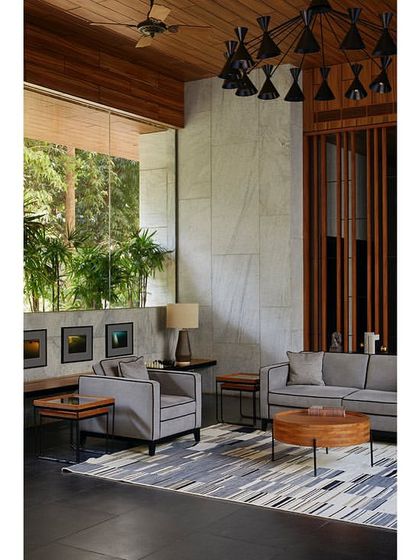 The garden lounge is a comfortable and utilitarian space designed for meetings, parties, or relaxation, featuring a wood-clad ceiling and a custom chandelier.