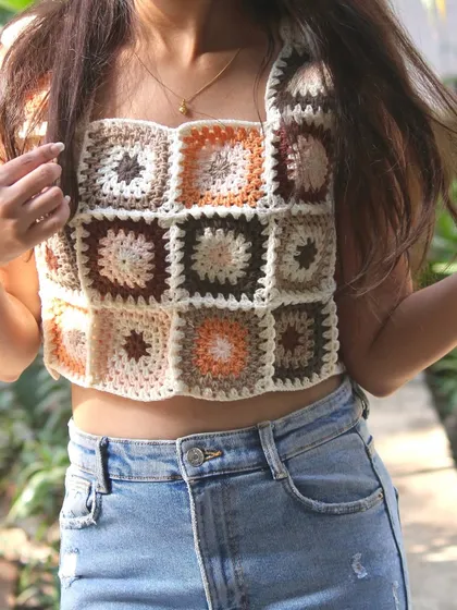 My granny square crop top is a true labor of love and one of my most popular wearable pieces. I carefully craft each square in earthy tones and stitch them together to create this boho-style top, perfect for sunny days.