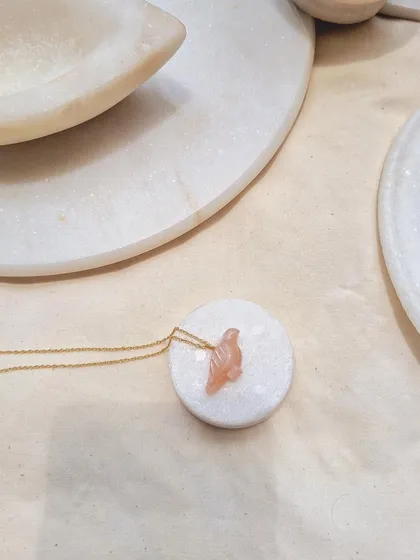 Another view of the peach moonstone 'dóve' pendant, a charm for peace, calm, and abundance.