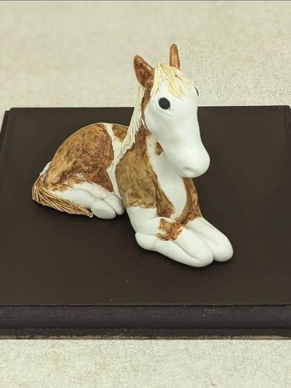 A handcrafted horse sculpture, made to be part of a larger birthday cake topper. I loved the challenge of creating this palm-sized animal, focusing on its gentle expression and coloring.