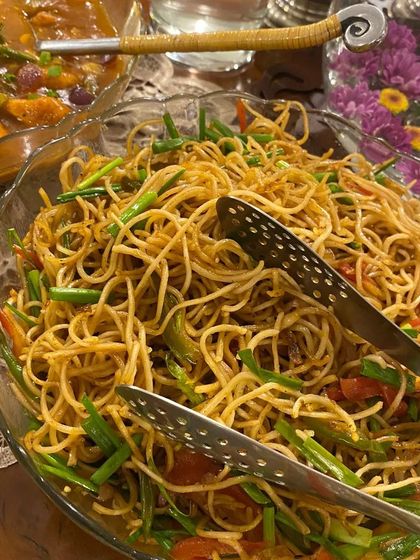 A generous serving of our Chilli Garlic Noodles, tossed with fresh spring onions and bell peppers. This dish is a staple for our Asian-themed party menus.