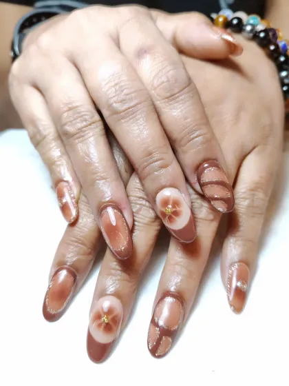 An earthy and elegant design featuring a brown cat-eye base with hand-painted floral and line art details.