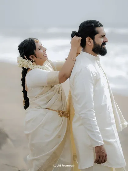 A playful, candid moment as the bride helps the groom with his hair on the beach. It's these small, unscripted interactions that tell the real story.