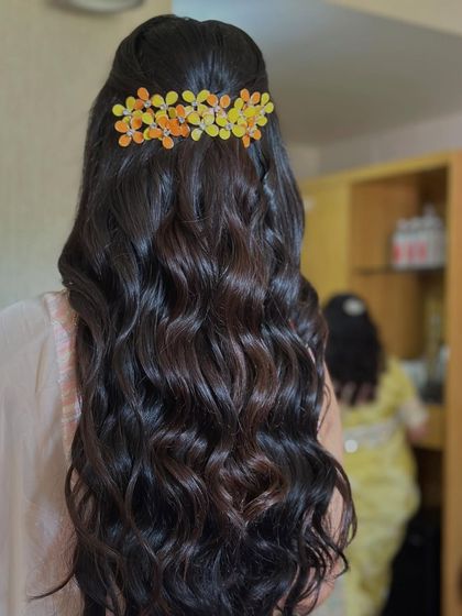 Simple, soft waves with a colorful floral clip. This is an easy and beautiful hairstyle for a daytime event or a pre-wedding function.