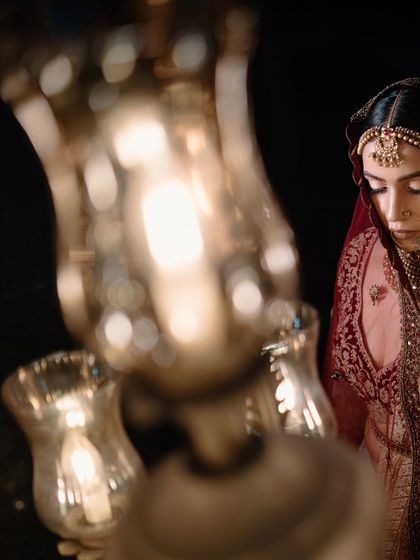 An artistic close-up of the bride, with the focus on her eyes, partially obscured by a chandelier.