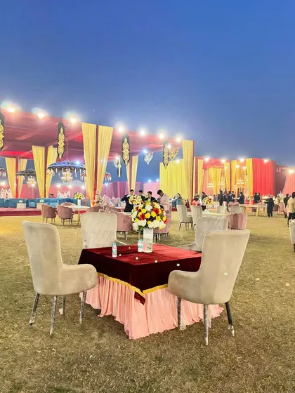 A simple yet elegant table setting on the lawn, with the grandly decorated main tent in the background.