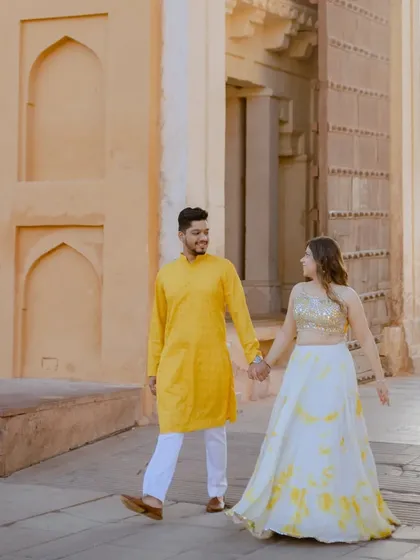A candid walking shot through the sunlit grounds of Amber Fort. These unposed moments often result in the most natural and cherished photographs from a pre-wedding session.