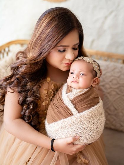 A mother's gentle touch. This close-up shot focuses on the tender bond between a new mom and her peacefully sleeping baby.