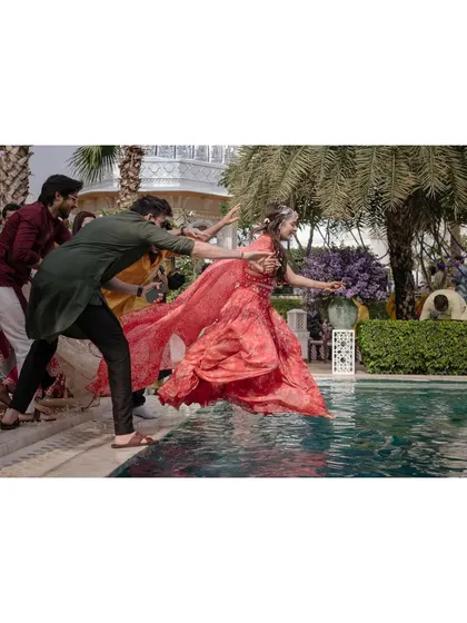 Just after their haldi, Anaaya and Nikunj are thrown into the pool by their friends. This spontaneous and fun moment captures the wild energy and celebratory spirit of their wedding.