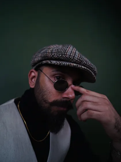 Adjusting the sunglasses in this shot adds a bit of character. It's a great example of a subtle, natural pose for a men's accessory or portrait photoshoot.