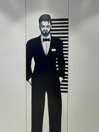 A close-up of the gents' washroom mural, a stylish and modern portrait that adds character to an often-overlooked space.