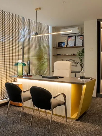 Another principal architect's cabin, this one featuring a custom desk with a curved, mustard-yellow base. The design is clean and minimal, with ample natural light and carefully selected decor to reflect personal style.