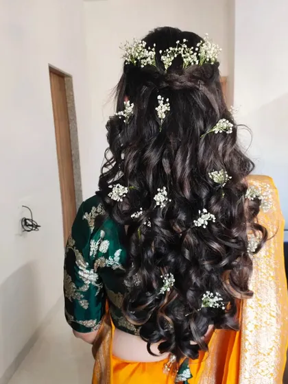 A hairstyle can make all the difference. For this Haldi look, I created soft, open curls and decorated them with delicate baby's breath flowers for a fresh and romantic feel.