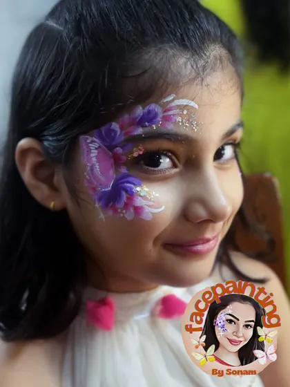 A lovely purple butterfly nestled among flowers and glitter. The smile on her face says it all.