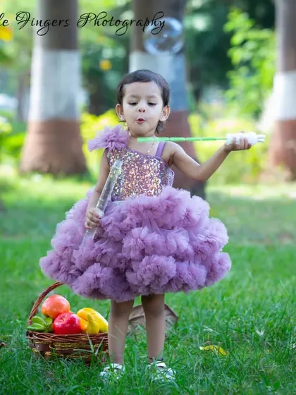 A little girl in a lovely purple dress, completely lost in the magic of blowing bubbles in a park. These are the whimsical, innocent moments of childhood I aim to freeze in time.