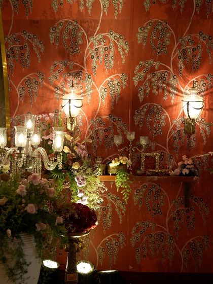 A view of the opulent entrance decor, where candelabras and lush floral arrangements were set against the richly patterned fabric wall.