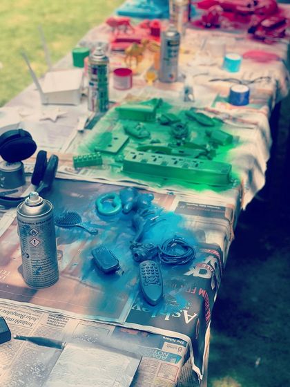A detail shot of the painting process. We used vibrant spray paints to give new life to old objects like remote controls and headphones, transforming them into our artistic palette.