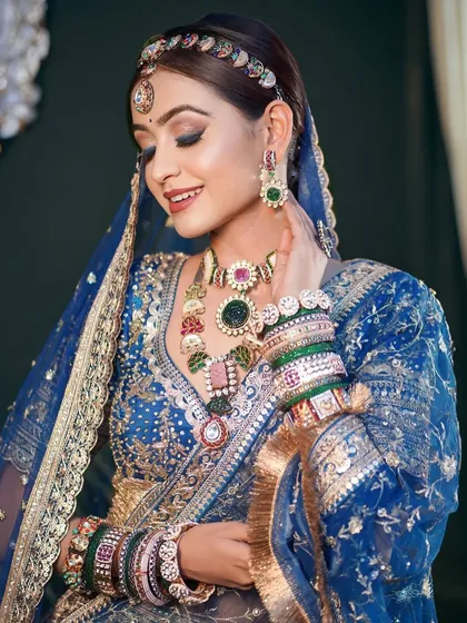 The modern Indian bride is uber glam and sure of herself. This look features a stunning blue lehenga with multi-colored jewelry and bold, beautiful makeup.