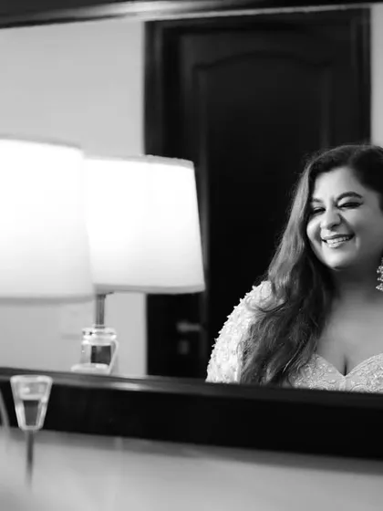 A bride's joyful reflection. This candid black and white shot captures a genuine moment of happiness while getting ready.