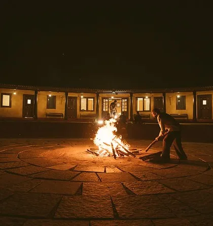 A bonfire being prepared in the central courtyard of the Charming Cottage in Sakleshpur, perfect for a cozy evening under the stars.