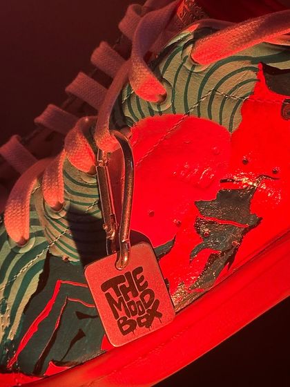 A close-up of the trippy, experimental Adidas Stan Smiths. The red light gives it a crazy, intense vibe.