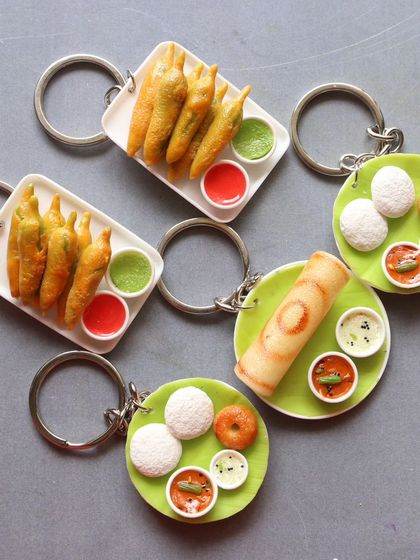 A pair of South Indian breakfast keychains next to mirchi bajji keychains, showing different gift options.