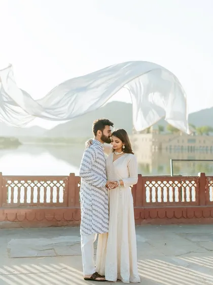 A moment of pure cinematic romance at Jal Mahal. The flowing white fabric catches the light beautifully, creating a dreamy and ethereal image against the serene lake palace.