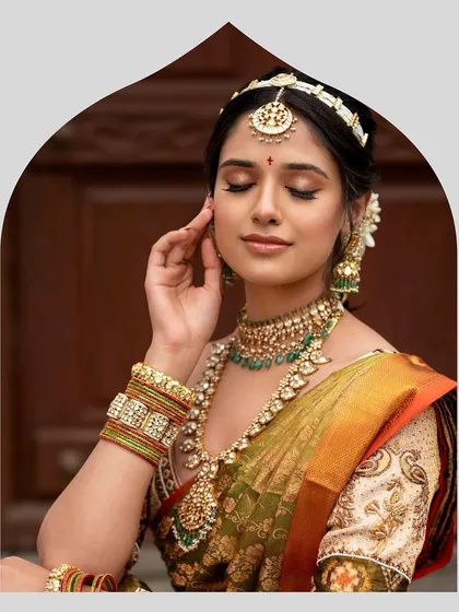 A serene moment, capturing the bride's elegant profile and the intricate details of her jewelry and custom-embroidered blouse. The craftsmanship is designed to complement her natural grace.