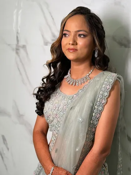 A dreamy engagement look in a pastel green lehenga. The makeup is soft and shimmery, with highlighted curls framing her face.