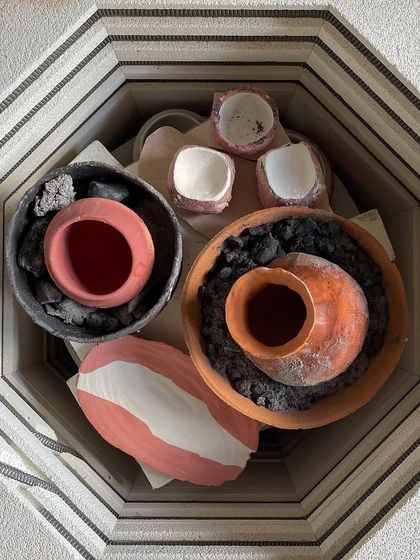 A saggar firing in progress. We packed our pieces in containers with combustible materials to create a smoky, atmospheric effect in the electric kiln.