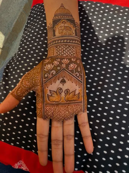 The palm section of a royal-themed design. It features two swans below a traditional arch, with an elephant and palace dome motif on the wrist.