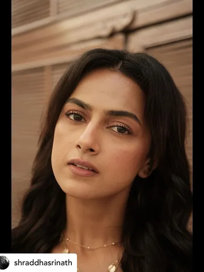 An intimate close-up from the photoshoot with Shraddha Srinath, focusing on the natural makeup and simple, elegant jewelry.