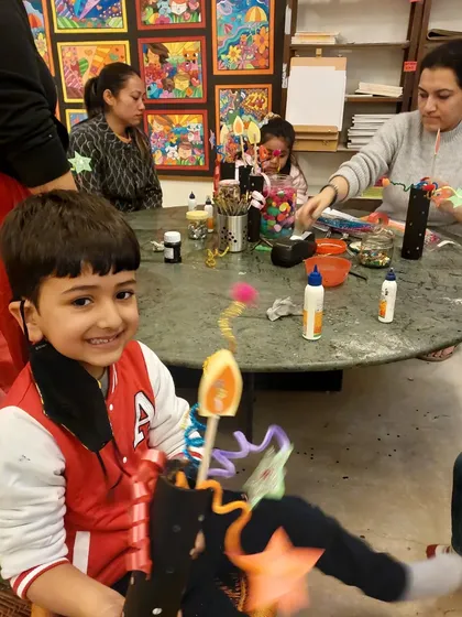 This happy student is showing off the whimsical party blower he made during our New Year's crafting session. It is a fun mix of recycled materials, ribbons, and stars.