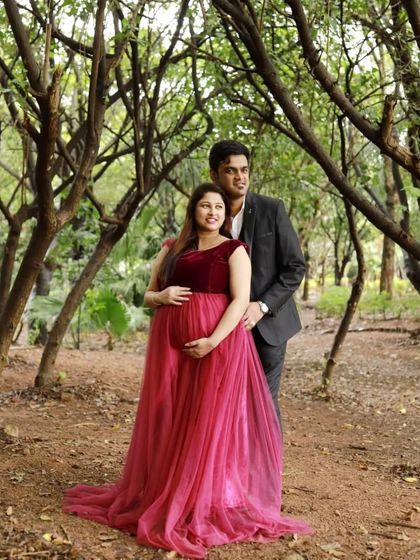 A simple and sweet couple's maternity photo in a forest setting. The client is wearing a beautiful maroon velvet and tulle gown that complements the natural surroundings.