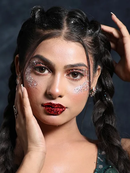 A close-up of this stunning glittery party makeup. The focus is on the sparkling eyes and bold red lip, creating a look that's sure to turn heads.